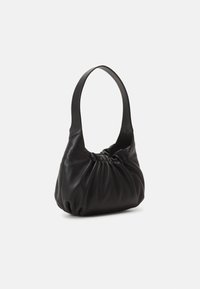 Musta nahkainen käsilaukku, jossa on pehmeä, kerrostettu muotoilu ja yksi leveä hihna. Sileä pinta, pyöreät muodot eikä näkyvää metalliosaa.