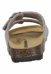 Braune Sandale mit Korksohle, die ein weiches, strukturiertes Obermaterial in Beige und einen verstellbaren Riemen mit einer metallischen Schnalle sowie einem konturierten Fußbett hat.