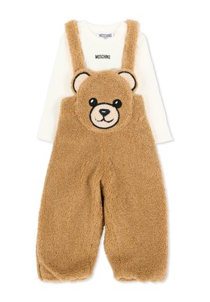 Peto suave de forro polar marrón con diseño de oso de peluche con tirantes, combinado con una camiseta blanca de manga larga Moschino para bebés o niños pequeños.