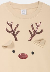 Beige sweatshirt met twee bruine pailletten gewei, twee kleine oren en een ronde, roze pailletten neus. Eenvoudig, cartoonachtig rendiergezicht ontwerp.