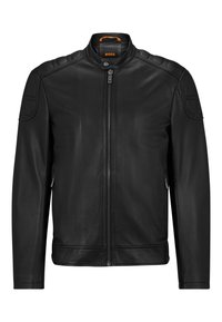 Svart läderjacka med dragkedja fram, hög krage och vadderade axelpartier. Har sidodragkedjor och en slät, glänsande yta.