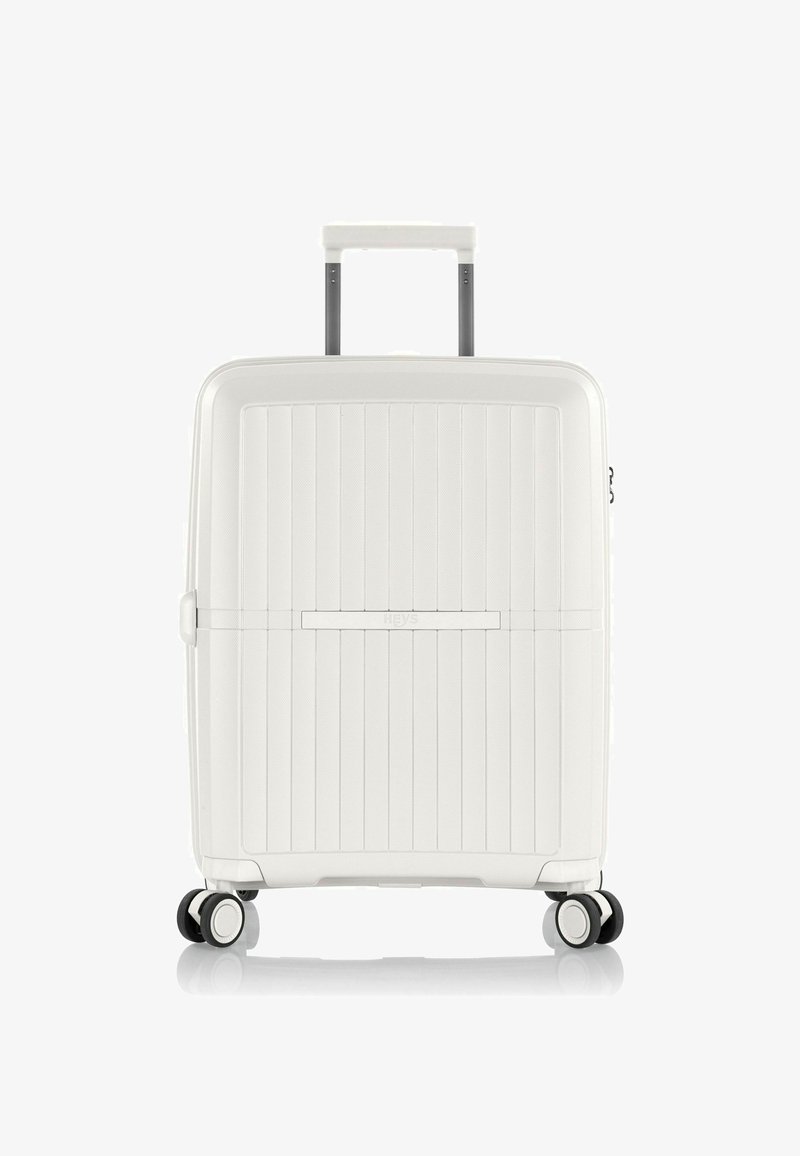 Valigia rigida bianca con scanalature verticali, manico estensibile e quattro ruote multidirezionali. Presenta un logo discreto e una superficie testurizzata.