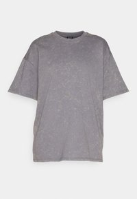 Šedé oversized tričko vyrobené z měkké tkaniny s mírně vybledlým povrchem, s kulatým výstřihem a spadlými ramenními švy.