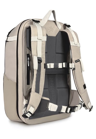 Zaino beige con schienale imbottito, spallacci regolabili, accenti grigi e più punti di attacco; progettato per un supporto ergonomico e durata.