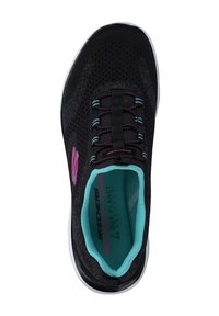 Zapatilla atlética negra con parte superior de malla, acentos en púrpura y teal, plantilla de espuma viscoelástica y suela blanca. Incluye cordones para ajustar el calce.