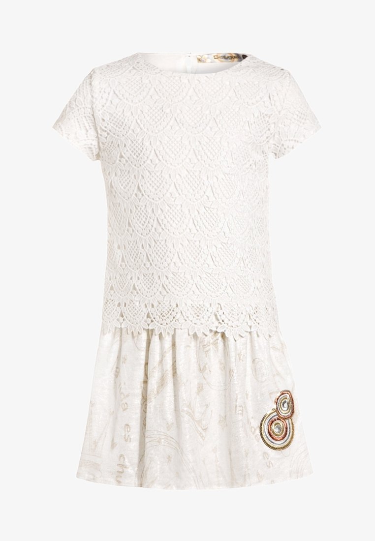Robe blanche à manches courtes avec corsage en dentelle superposée, encolure ronde, jupe froncée avec un imprimé subtil et patch brodé circulaire près de l'ourlet.
