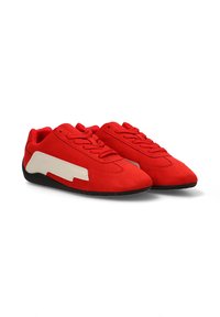 Zapatillas de ante rojo con un diseño angular blanco en contraste a lo largo del costado, punta redonda y suela de goma negra. Cuenta con seis ojetes para los cordones.