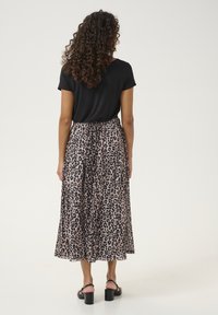 Sort kortærmet top parret med en svævende midi-nederdel i leopardprint, som har en elastisk talje og et let, struktureret stof.