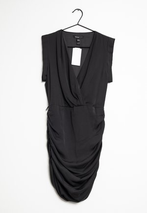 Zwarte jurk met korte mouwen, gedrapeerd ontwerp en geplooide textuur aan één kant. De stof lijkt glad en lichtgewicht, hangend aan een haak.
