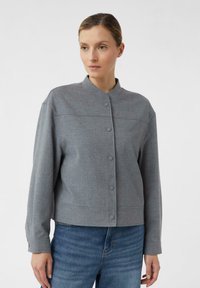 Szara krótka kurtka z kołnierzem typu mandarynka, zapinana na guziki, z długimi rękawami. Miękka w dotyku, o minimalistycznym designie z delikatnymi detalami szwów.