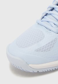 Světle modrá sportovní bota s prodyšným síťovaným svrškem, hladkými syntetickými překryvy a texturovanou gumovou podrážkou s jemnými akcenty.