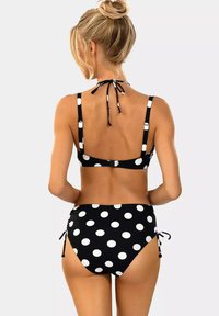 Czarny bikini w kropki z grubymi ramiączkami, z wiązaniem z tyłu i regulowanym stanem wysokim. Gładki materiał z białymi okrągłymi wzorami.