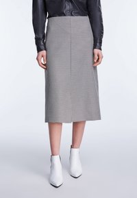 Grijze en zwarte houndstooth midi rok, getailleerd ontwerp, soepele stof, rechte snit, gecombineerd met witte enkellaarsjes.