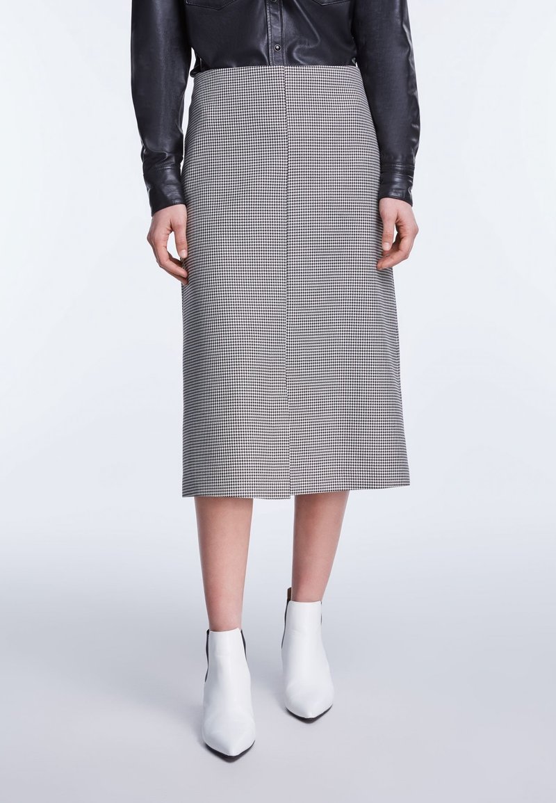Grijze en zwarte houndstooth midi rok, getailleerd ontwerp, soepele stof, rechte snit, gecombineerd met witte enkellaarsjes.