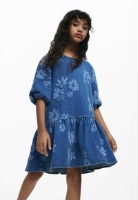 Blå denimkjole med blomsterprint, rund halsudskæring, puffede ærmer og indsnævret skørt med flared kant. Glat tekstur, afslappet design.