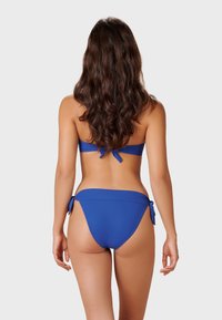 Bikini-set i solid blå, med en bandeauöverkropp med knytdetalj och matchande lågmidjade bottnar med sidosnörningar. Slät, stretchig tyg.