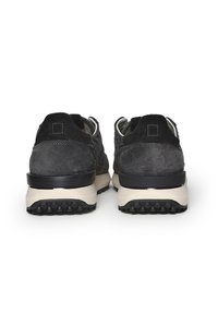 Scarpe sportive in pelle scamosciata nera con suole in gomma beige, dotate di schienali testurizzati e un supporto rinforzato per il tallone, per garantire stabilità.