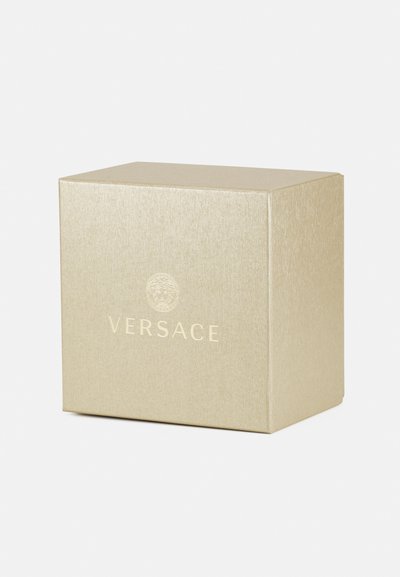 Kuldse tekstuuriga ruudukujuline kast, mille esiküljel on püstitatud Versace'i logo. Lihtne disain, sile viimistlus.