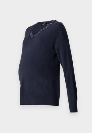 Mornarško modra pletena bluzica za nosečnice z V-izrezom in čipkastim detajlom na ovratniku. Dolgi rokavi in sproščen kroj za udobje.