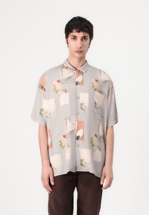 Short-sleeve shirt, light gray fabric featuring a collage of pastel-colored patterns, including birds and floral accents, with a chest pocket.