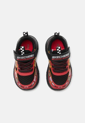 Zapatillas Skechers negras y rojas para niños con etiqueta "Adventure Racer", tiradores a cuadros, rayo y pegatinas temáticas de carreras.
