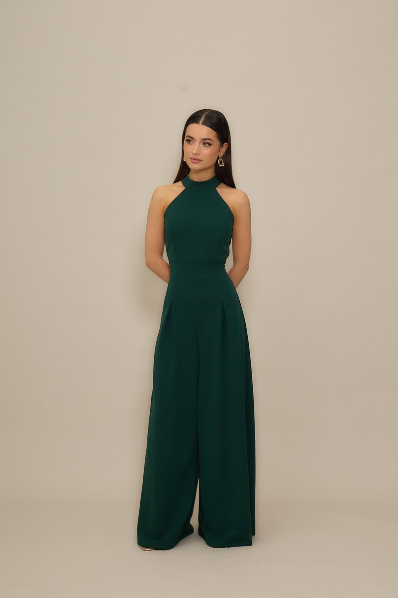 Ολόσωμη φόρμα σε σμαραγδί πράσινο με λαιμόκοψη ψηλή, εφαρμοστή μπάσκα και φαρδιά, αέρινα παντελόνια. Ομαλή υφή υφάσματος με ελάχιστες λεπτομέρειες.