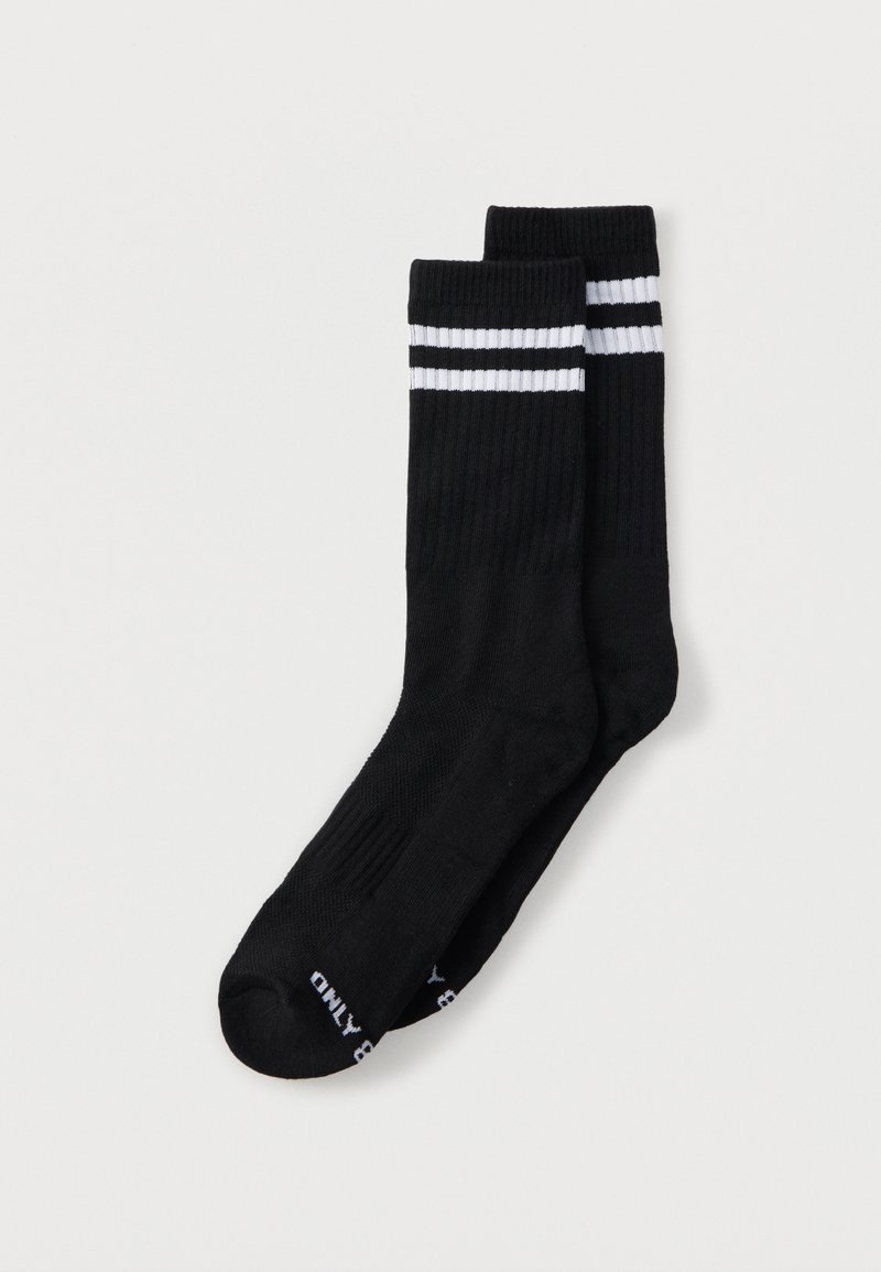 Black socks with a ribbed texture, featuring two white stripes at the cuff and branding on the sole. Standard length design.