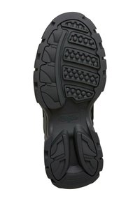 Suela de zapato de goma negra con un patrón texturizado que presenta estrías y agarres circulares, diseñada para tracción y durabilidad.