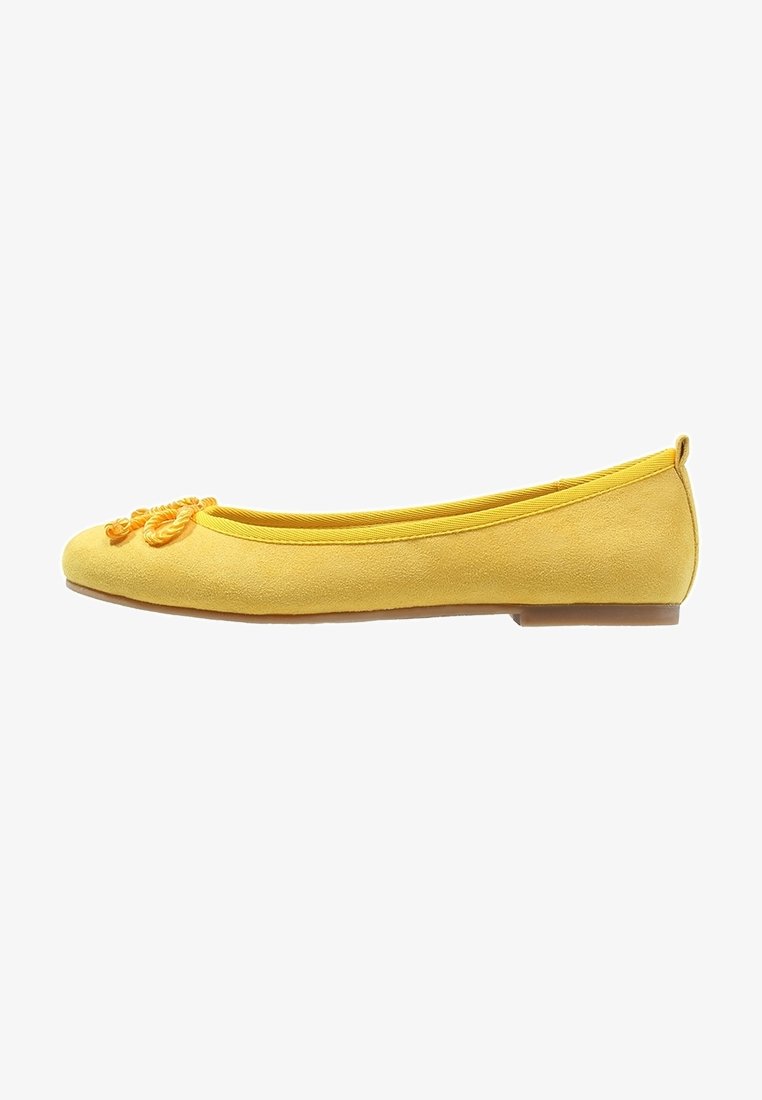 Ballerine en daim jaune avec un nœud décoratif en cordon torsadé sur le bout, bout rond fermé et semelle plate.
