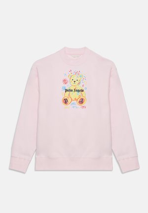 Lyserød sweatshirt med en farverig tegning af en teddybjørn og teksten "Palm Angels" på frontens midte.