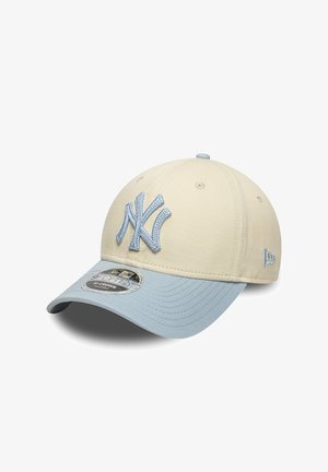 Gorra de béisbol beige y azul claro con logo "NY" bordado en relieve en la parte frontal y correa ajustable, vista en ángulo de tres cuartos.