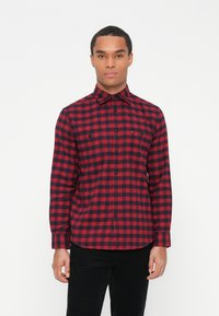 Rood en zwart geblokt shirt, lange mouwen, knoopsluiting kraag, twee borstzakken, gemaakt van een zachte stof met een vlakke textuur.