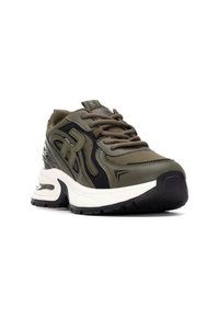 Zapatilla deportiva de color verde oliva con acentos negros, tejido texturizado, diseño de cordones y una suela blanca gruesa con una unidad de aire visible.