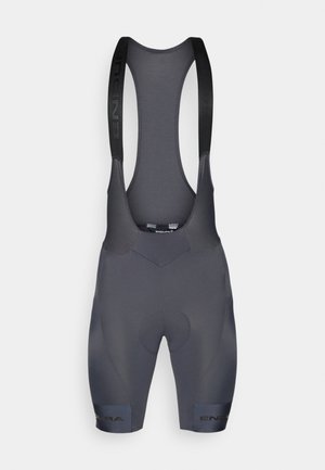 Grijze fiets-bibshorts gemaakt van rekbare stof. Kenmerken zijn onder andere een gepolsterde zitting, een logo op de beenband en verstelbare schouderbanden voor de pasvorm.