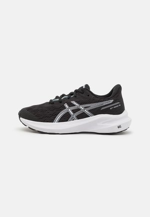 Shoe atlético preto com parte superior em malha, detalhes em prateado e entressola branca. Apresenta uma sola acolchoada e um design texturizado e flexível.