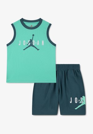 Kupačka košarkaška majica na bretele u tirkiznoj boji s tamnoplavim obrubom i logotipom Jumpman, uparena s tamnoplavim kratkim hlačama koje imaju isti Jumpman motiv.