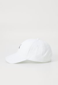 Witte baseballpet van katoen met een gebogen rand. Bevat een geborduurd logo op de voorkant, zes ventilatiegaten en een gestikte afwerking.