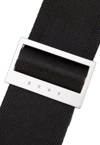 Zwarte stoffen riem met een geweven textuur en een rechthoekige zilverkleurige metalen gesp met de gegraveerde merknaam "BREE".