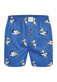 Shorts de bain bleus avec un motif de pélican, ceinture élastique, fermeture à bouton et deux boutons rouges à l'avant. Fabriqués en tissu léger.