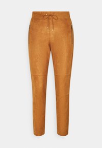 Bruine suède broek met een tapered fit, voorzien van een drawstring tailleband en twee ritszakken aan de zijkant. Soepele textuur met naaddetails.