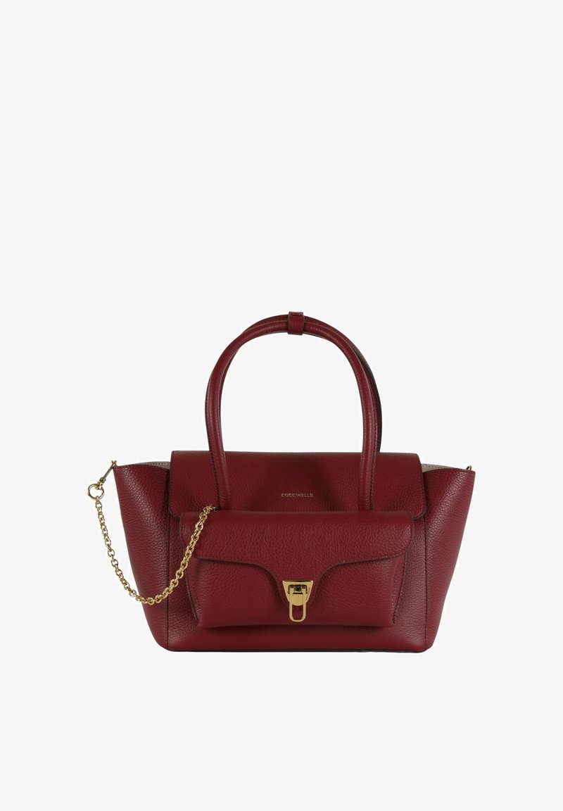 Borsa a mano in pelle color bordeaux con due manici, tasca frontale con patta e chiusura in metallo dorato, e catena decorativa dorata su sfondo bianco.