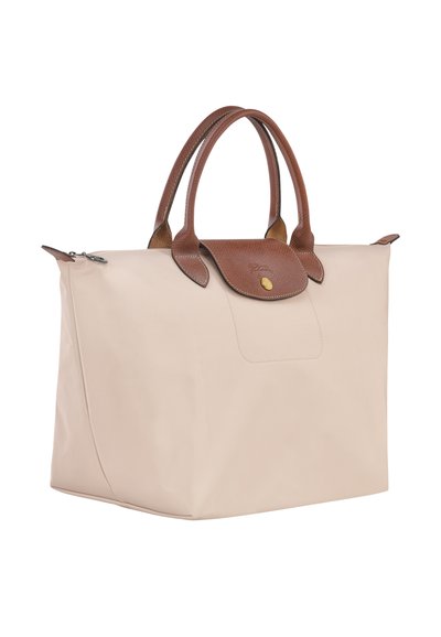 Beige nylon tote bag with brown leather handles and flap, featuring a gold-tone button and smooth texture. Zippered top closure.
