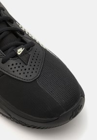 Svart Nike-sneaker med mesh-overdel, polstret krage og perforerte detaljer. Gummisåle med teksturert grep og logo-aksent.