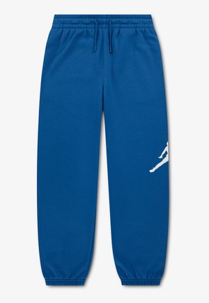 Pantalon de survêtement bleu avec une taille élastique, un cordon de serrage, des chevilles resserrées et un motif blanc de silhouette bondissante sur la jambe gauche.