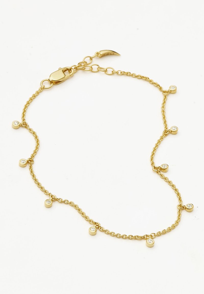 Zlatý náramok s reťazou, ktorý obsahuje malé okrúhle kovové akcenty s vsadenými priehľadnými kameňmi, čím vytvára jemný a zložitý dizajn.