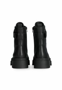Stivaletti neri in pelle con una texture liscia, dotati di una suola spessa e chiusura con zip. Inclusa una fascia attorno alla caviglia con un logo.