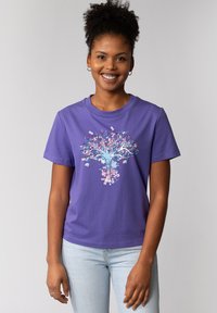 T-shirt en coton violet avec un design d'arbre coloré présentant des accents bleus, roses et verts, à manches courtes et à encolure ronde.