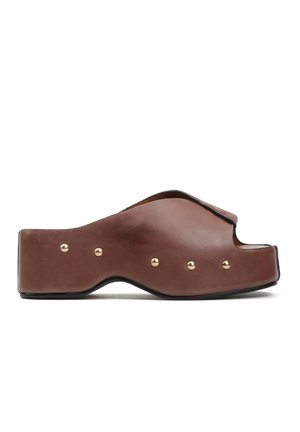 Brązowa skórzana sandałka na platformie z odkrytymi palcami, sześć złotych ćwieków wzdłuż boku i profilowana podeszwa na białym tle.