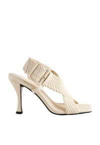 Sandale à talons hauts beige avec des brides tissées, un bout carré, une boucle ajustable et une semelle profilée.