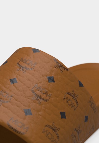 Sandalo con zeppa marrone dalla texture con motivo a logo MCM nero ripetuto e motivi a diamante sulla fascia.